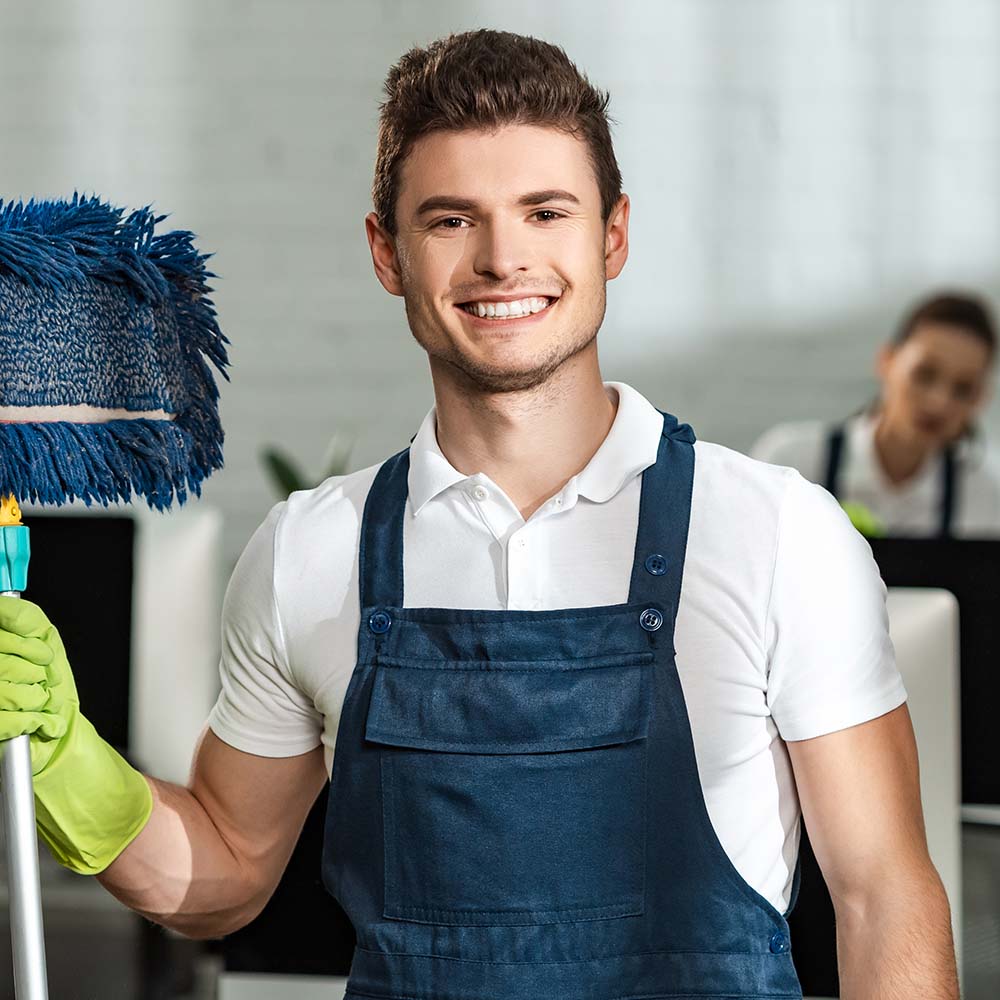 A cheerful Top Sydney Cleaners team member holding a mop