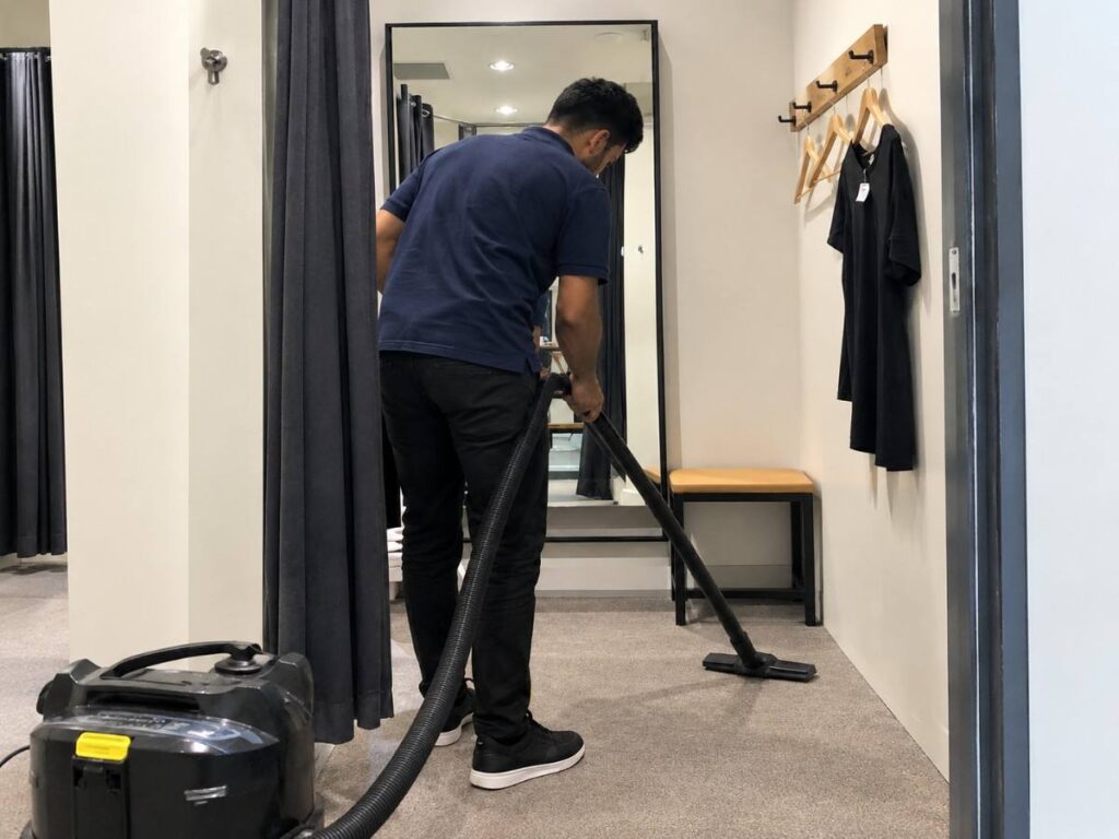 Fitting room being vacuumed as part of a retail cleaning checklist