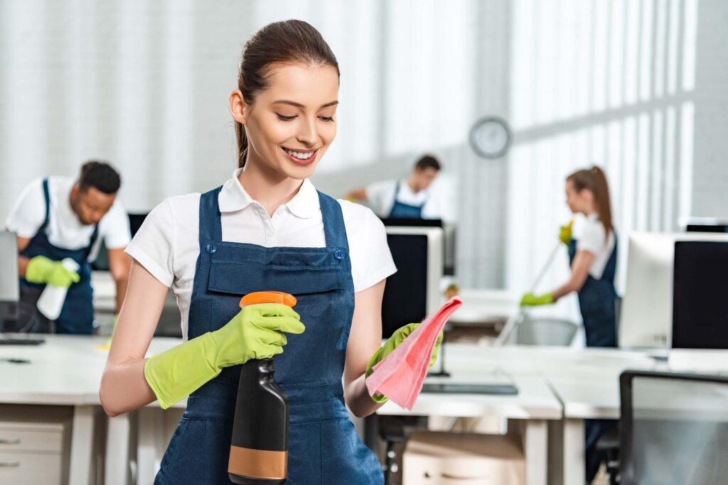 A cleaner spraying detergent while cleaning a commercial space