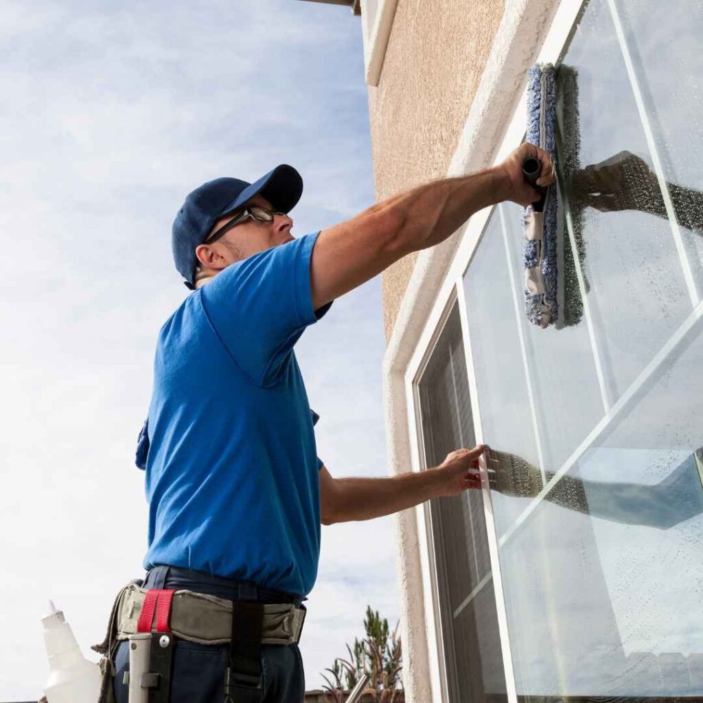 A cleaner polishing a window ahead of your next holiday rental guests