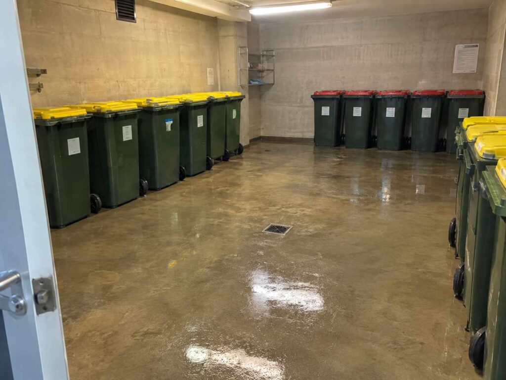Freshly washed apartment bin room with clear floor drain, an example of shared facility cleaning in Sydney