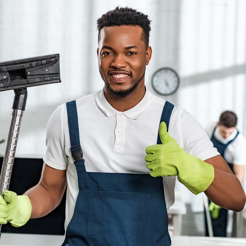 A Top Sydney Cleaners team member in uniform, holding vacuum equipment