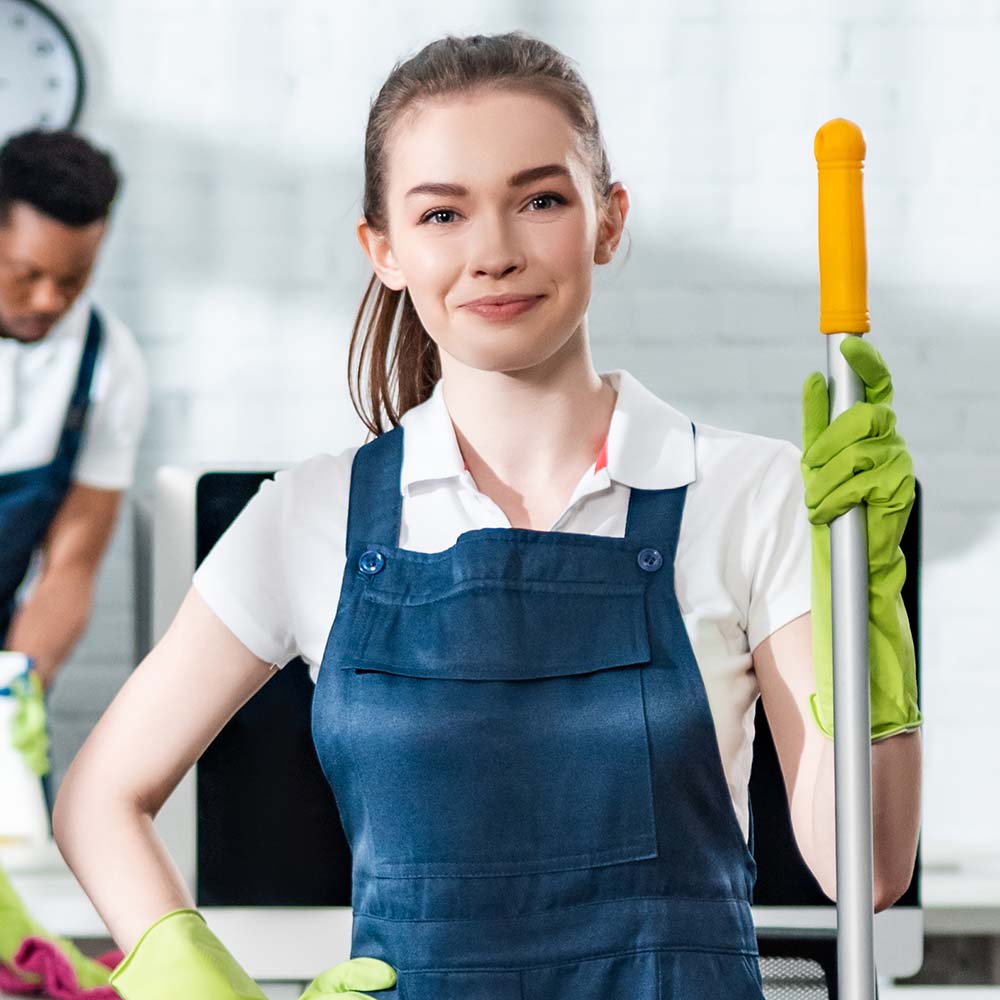 Smiling Top Sydney Cleaners team member in uniform holding a mop