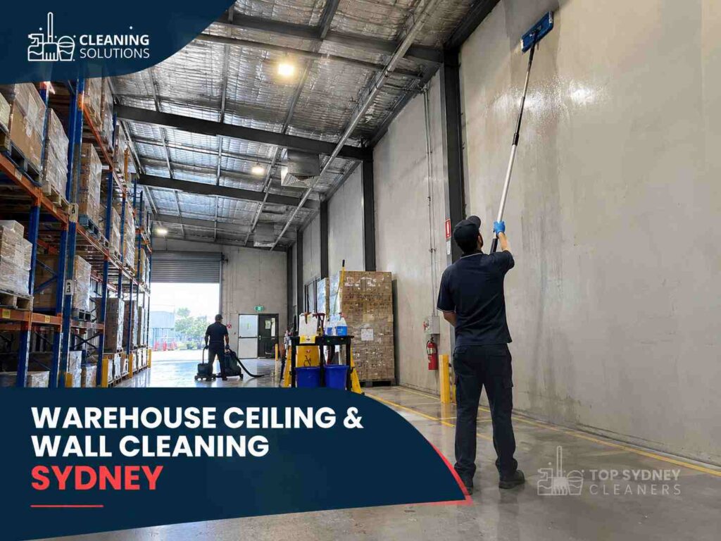 A cleaner cleaning wall and ceiling with cleaning equipment at warehouse cleaning service